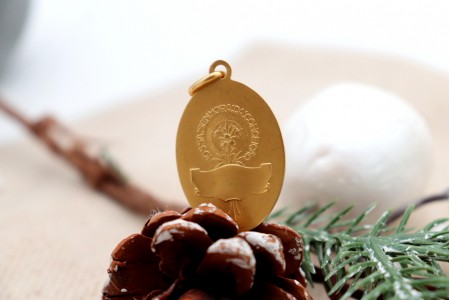 Medalha em ouro em forma oval com Nossa Senhora da Conceição em vulto perfeito relevado e argola de suspensão.