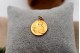 Medalha em ouro com São Expedito em relevo e argola de suspensão.
