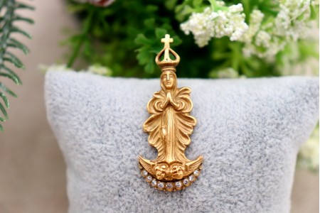  Pendente em ouro com nossa senhora da Conceição com as mãos postas, de vulto perfeito relevado com diamantes (9) em talhe brilhante 8/8 e coroa vazada.