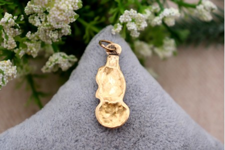 Pendente em ouro com Nossa Senhora da Conceição com as mãos postas, de vulto perfeito relevado e coroa, argola de suspensão