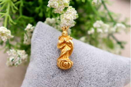 Pendente em ouro com Nossa Senhora da Conceição com as mãos postas, de vulto perfeito relevado e coroa recortada, argola de suspensão