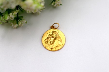 Medalha em ouro amarelo com Santo António de Pádua em relevo.