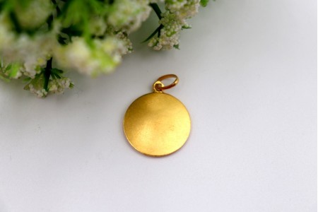 Medalha/pingente circular em ouro amarelo com Santo António de Pádua em relevo.