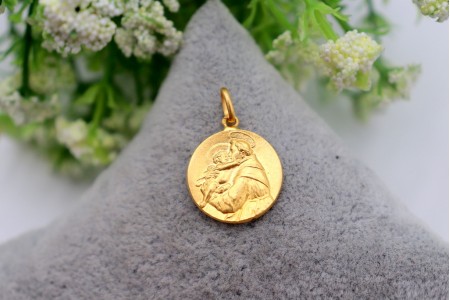 Medalha/pingente circular em ouro amarelo com Santo António de Pádua em relevo.