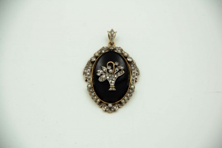 Medalhão em ouro bicolor com aplicação de boquet de flores sobre onix convexo 