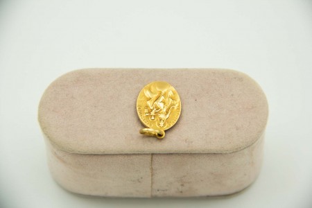 Medalha em ouro amarelo em formato elíptico com Nossa Senhora e menino em relevo