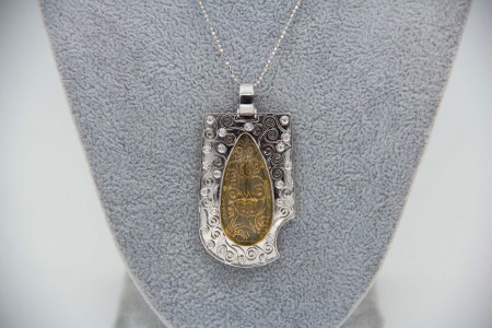 Medalha em ouro bicolor com enrolamentos, diamantes (22) em talhe brilhante 8/8 