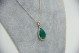 Medalha de ouro branco com diamantes (22) em talhe brilhante (8/8) e esmeralda l