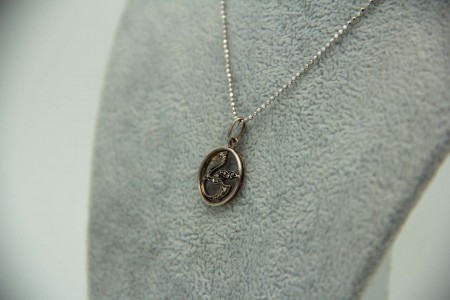 Medalha em ouro bicolor com cisne e lascas de diamantes.