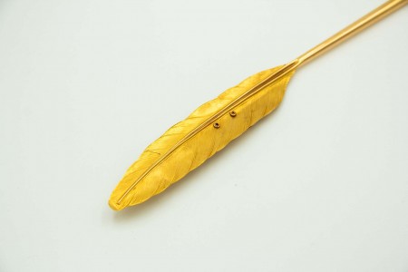 Pena em ouro amarelo para escrita com livro aberto em vulto perfeito