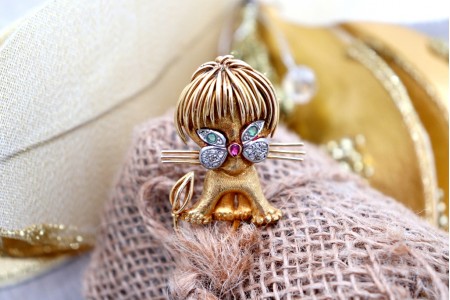 Pregadeira em ouro em forma de leãozinho com lascas de diamantes