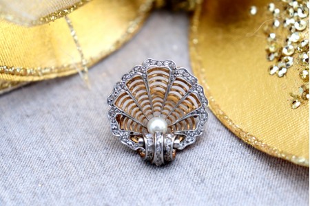 Pregadeira em ouro em forma de concha com lascas de diamantes