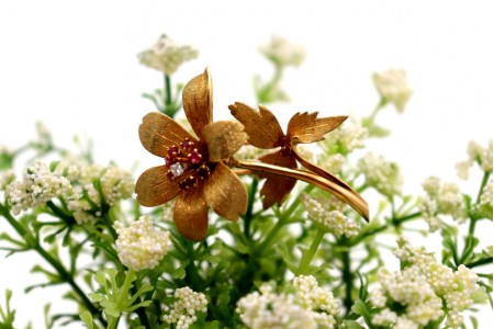 Pregadeira em ouro em forma de flor com nove (9) rubis