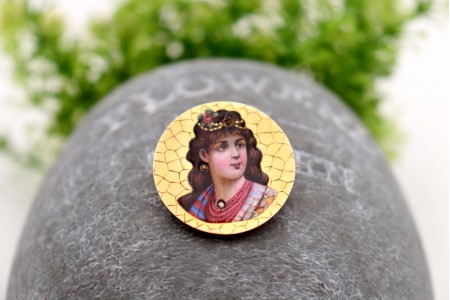 Pregadeira em ouro com gradinha e figura de dama em esmalte 