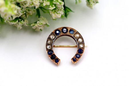 Pregadeira em ouro em forma de ferradura com diamantes coroados e safiras 