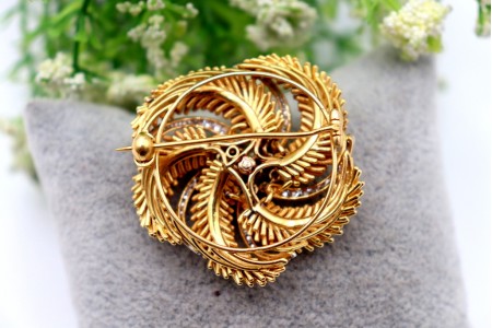 Pregadeira em ouro bicolor circular com relevos e diamantes em talhe brilhante