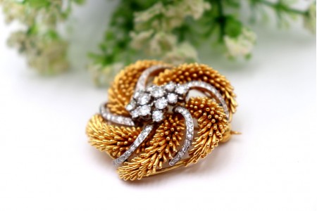 Pregadeira em ouro bicolor circular com relevos e diamantes em talhe brilhante