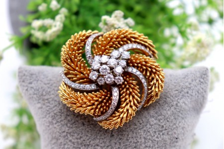 Pregadeira em ouro bicolor circular com relevos e diamantes em talhe brilhante