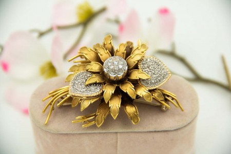 Pregadeira de ouro em forma de boquet e ramos de flores com diamantes (36) em talhe brilhante aplicados em ouro branco.