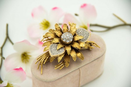 Pregadeira de ouro em forma de boquet e ramos de flores com diamantes (36) em talhe brilhante aplicados em ouro branco.