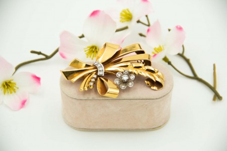 Pregadeira em ouro em forma de laço dom diamantes (14) em talhe brilhante aplicados em ouro branco.