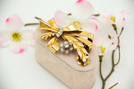 Pregadeira em ouro em forma de laço dom diamantes (14) em talhe brilhante aplicados em ouro branco.