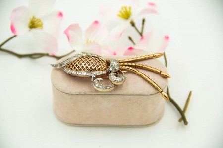 Pregadeira de ouro com gradinha recortada, três pingentes articulados e a aplicação de diamantes (41) em talhe brilhante sobre platina.