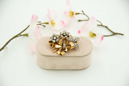 Pregadeira em ouro e platina com diamantes (31) em talhe brilhante em formato de flores e folhas sobre boquet.