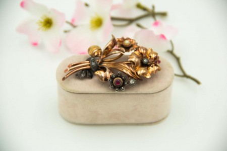 Pregadeira em ouro amarelo em forma de bouquet de flores com diamante em talhe brilhante e lascas de diamante sobre aplicações de prata.