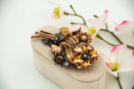 Pregadeira em ouro amarelo em forma de bouquet de flores com diamante em talhe brilhante e lascas de diamante sobre aplicações de prata.