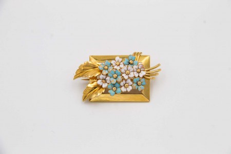 Pregadeira de ouro em forma de ramo de flores com pétalas em esmaltes policromados.