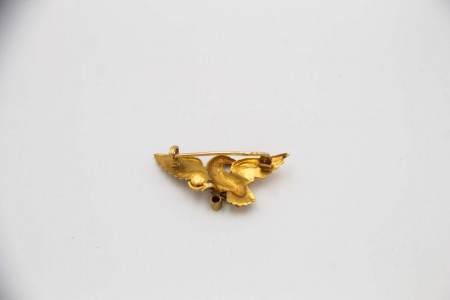 Pregadeira de ouro em forma de ave com diamante em talhe rosa aplicado.