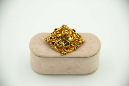 Pregadeira de ouro amarelo com pormenores de flores em esmaltes policromados.