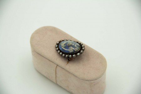 Pregadeira de ouro amarelo e prata com pérolas e ilustração protegida por vidro