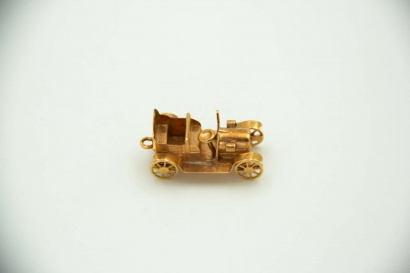 Medalha de ouro em forma de calhambeque em miniatura