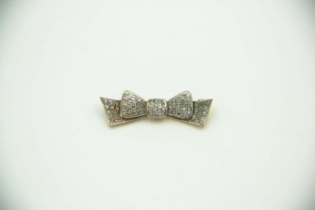 Pregadeira de ouro amarelo e branco em forma de laço com lascas de diamantes