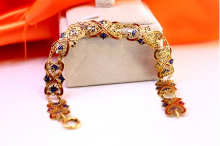 Pulseira em ouro esmaltada em tons de vermelho e azul com elos articulados.