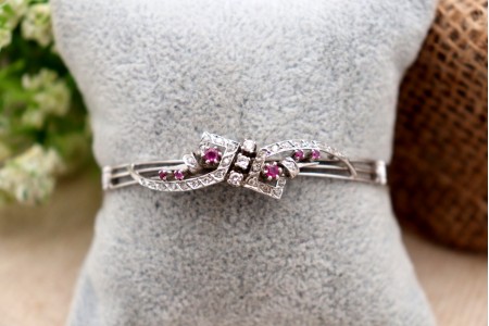  Pulseira em ouro branco ao estilo escrava de três fios com diamantes em talhe brinlhante e rubis sintéticoas calibrados.