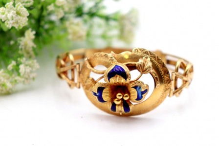 Pulseira em ouro com relevos e aplicações com flor no centro esmaltada