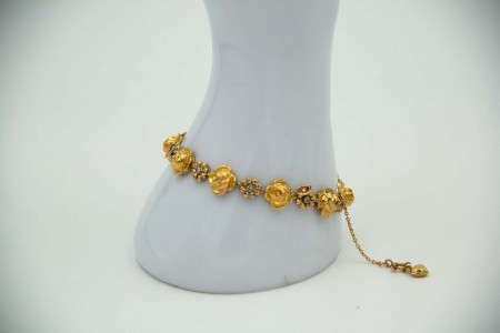 Pulseira de ouro amarelo em forma de rosas e flores com lascas de diamantes.