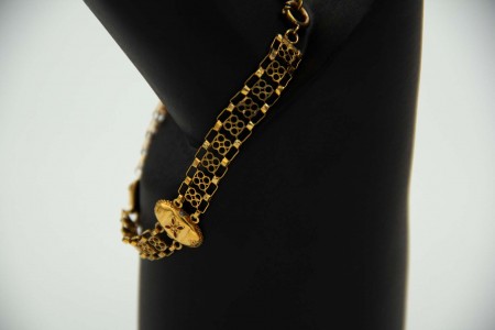 Pulseira de ouro amarelo com relevos e elos articulados.