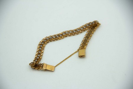 Pulseira articulada em ouro amarelo com pérolas e corrente de segurança