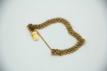 Pulseira articulada em ouro amarelo com pérolas e corrente de segurança