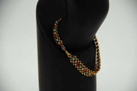 Pulseira de ouro amarelo articulada com turquezas, pérolas e rubis.