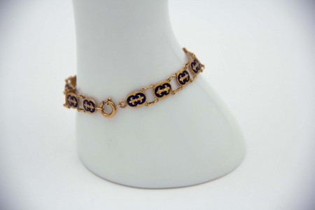 Pulseira fina em ouro amarelo articulada com flores de liz esmaltadas