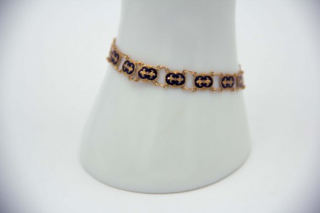 Pulseira fina em ouro amarelo articulada com flores de liz esmaltadas