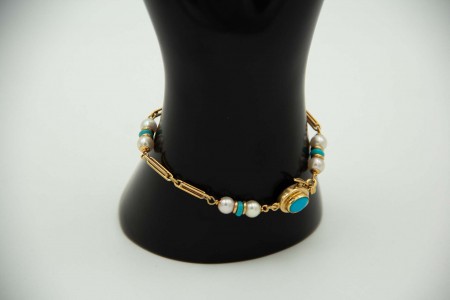 Pulseira articulada em ouro amarelo com oito pérolas e turquezas aplicadas.