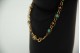 Pulseira em ouro amarelo com elos articulados e turquezas aplicadas.