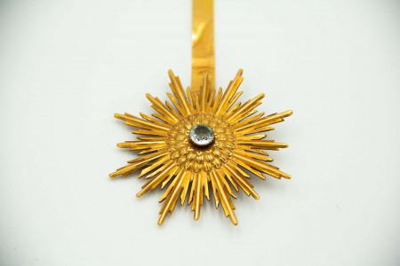 Resplendor em ouro com pedra no centro