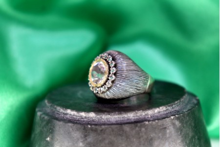 Anel em ouro e prata com zircónias envolvendo zircão central lapidado.